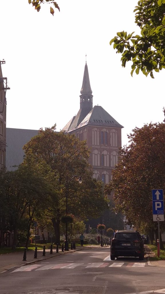wieża bazyliki konkatedralnej w Kołobrzegu widziana z ulicy jesienią