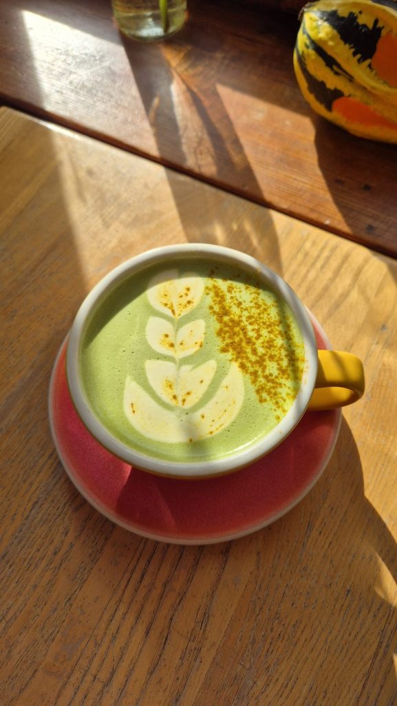 matcha latte z kurkumą na drewnianym stoliku w Colbergcoffee przy ul. Dubois